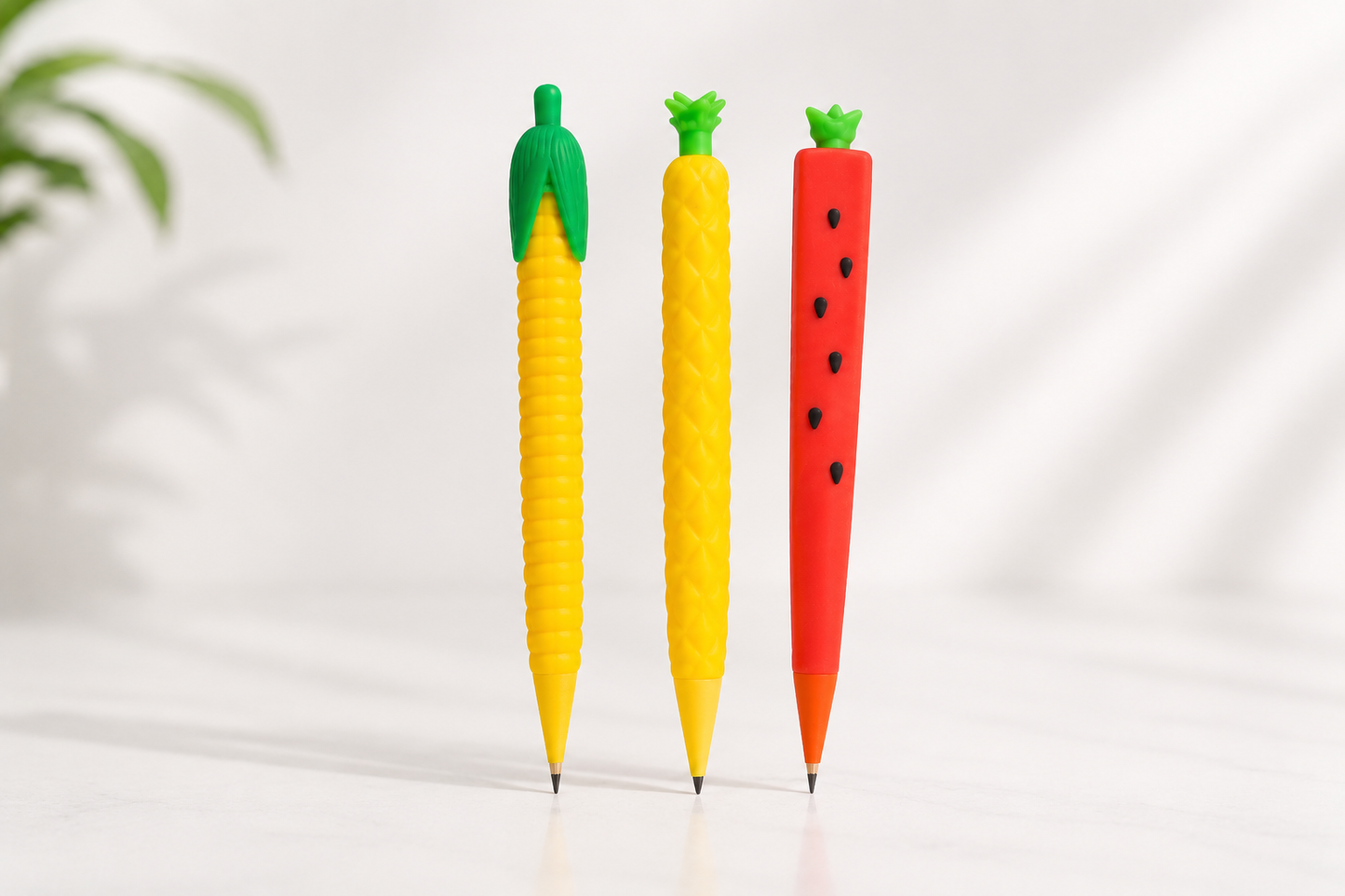 Three carrot-shaped pens in red, yellow, and green on a white background